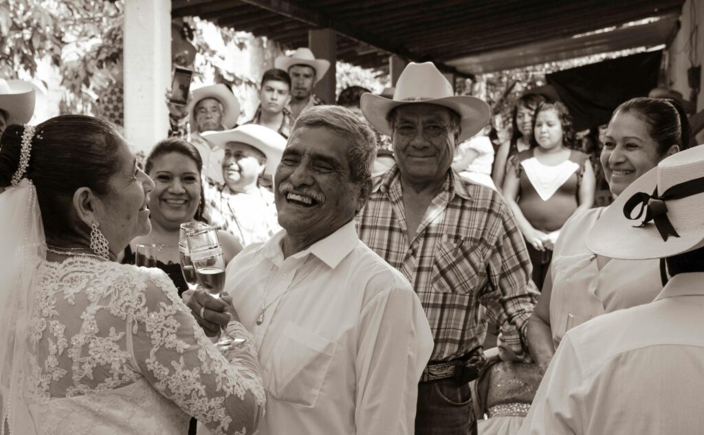 Lively wedding celebration with happy guests in traditional attire in Mexico.